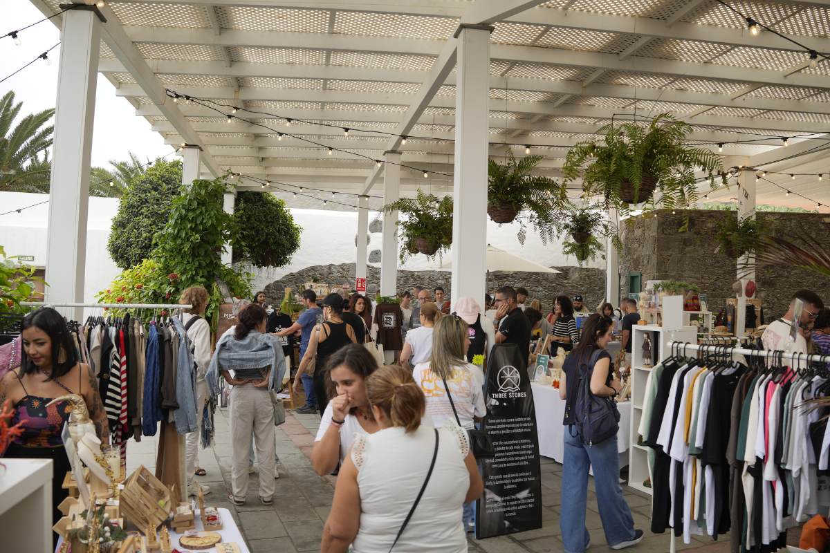 Visitantes disfrutando de los puestos de la 5ª Edición de Arucas es Arte, rodeando los stands con productos y actividades creativas